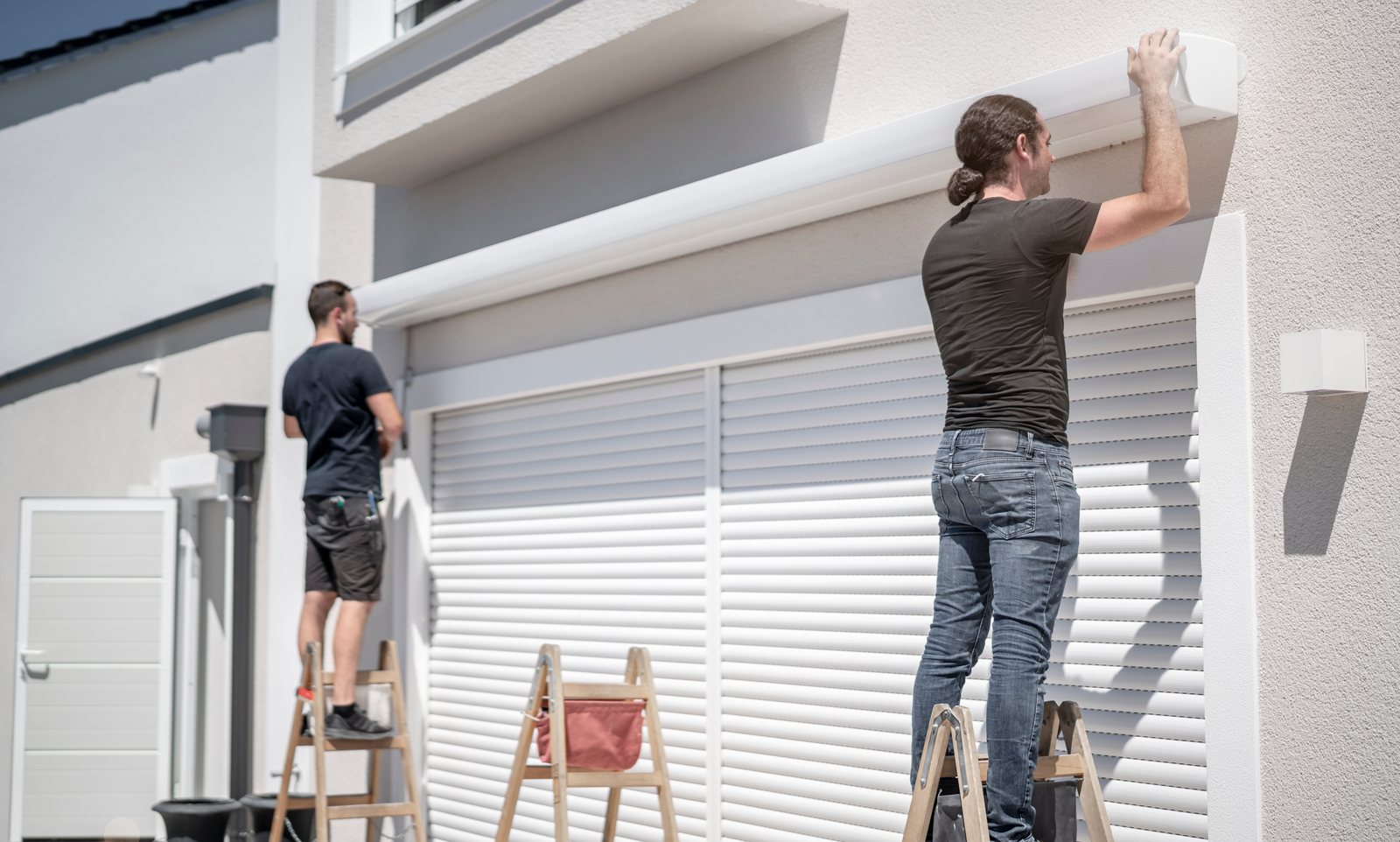 Monteure montieren gemeinsam einen Sonnenschutz